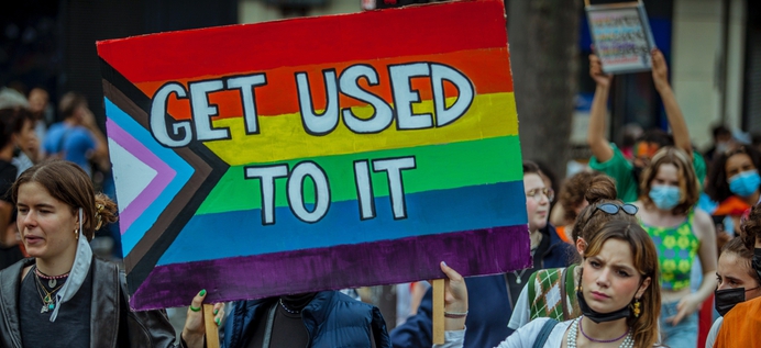 Vrouw met regenboog protestbord