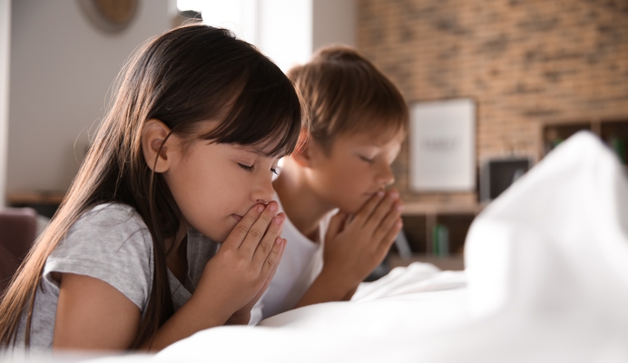 Kinderen bidden op bed